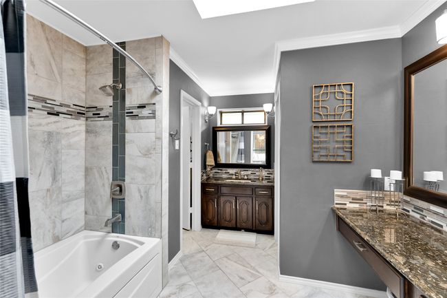 Bathroom with ornamental molding, shower / bathtub combination, tasteful backsplash, vanity, and marble look tiles | Image 24