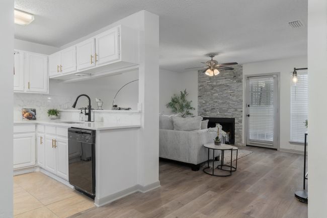 Kitchen featuring a sink, visible vents, white cabinetry, ceiling fan, and dishwasher | Image 21