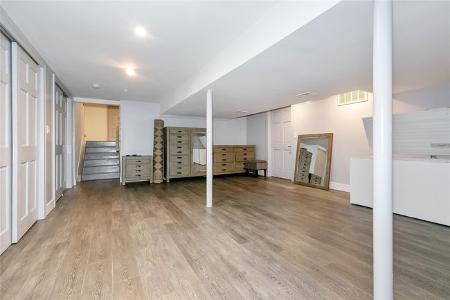 Finished below grade area featuring stairs, visible vents, light wood-style flooring, and baseboards | Image 24