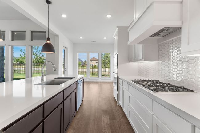 Kitchen featuring a sink, premium range hood, appliances with stainless steel finishes, light countertops, and recessed lighting | Image 26