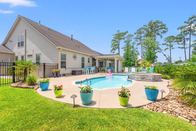 View of swimming pool featuring a ceiling fan, a patio area, a fenced backyard, and a pool with connected hot tub | Image 35