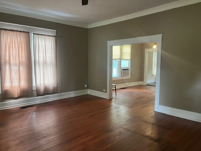 Empty room with crown molding, wood-type flooring, cooling unit, and ceiling fan | Image 4