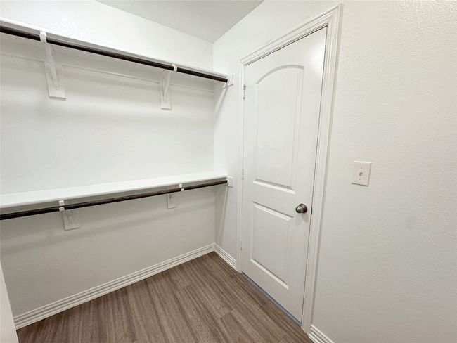 Walk in closet with dark wood finished floors | Image 9