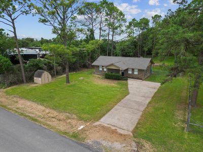 This property boasts a spacious lot with a long, private driveway leading to your serene retreat. Plenty of room for outdoor activities and ample parking for guests! | Image 3