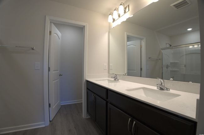 Full bathroom featuring wood finished floors, double vanity, and a shower | Image 11