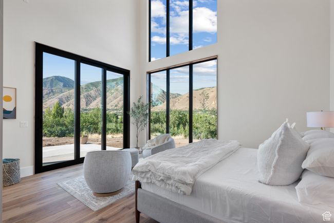 Bedroom featuring access to exterior, light wood-style floors, a mountain view, and a high ceiling | Image 37