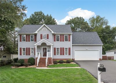 Colonial-style house with a front yard and a garage | Image 2