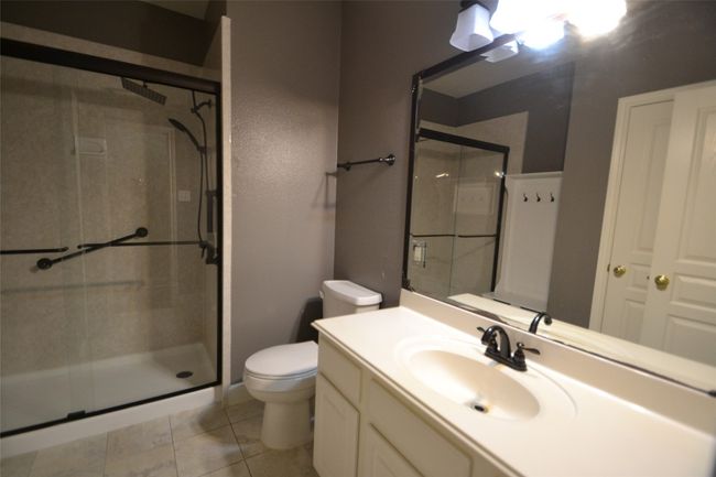 Bathroom with a shower stall, vanity, and tile patterned floors | Image 16