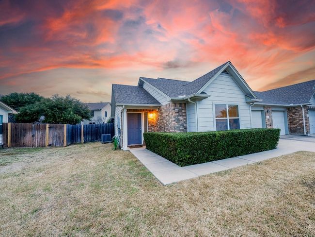 View of front of home with a garage, roof with shingles, a yard, and fence | Image 10