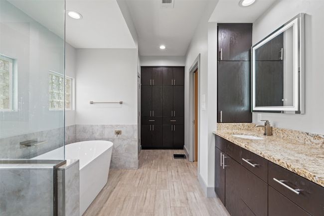 Bathroom with a soaking tub, tile walls, vanity, recessed lighting, and a walk in shower | Image 20