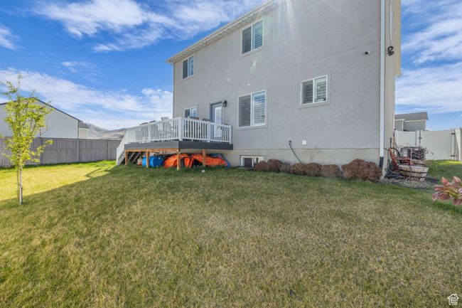 Back of house with a wooden deck, a lawn, and a fenced backyard | Image 31