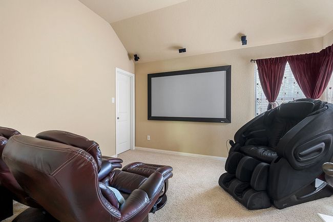 Carpeted home theater room with vaulted ceiling and baseboards | Image 4
