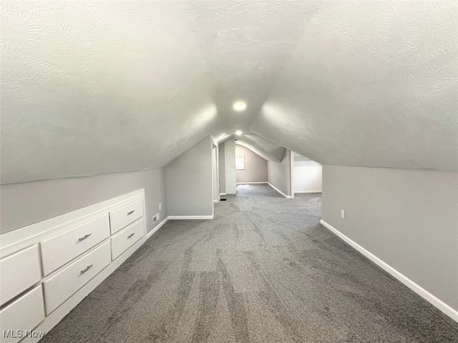 Bonus room with a textured ceiling, carpet flooring, vaulted ceiling, and baseboards | Image 10