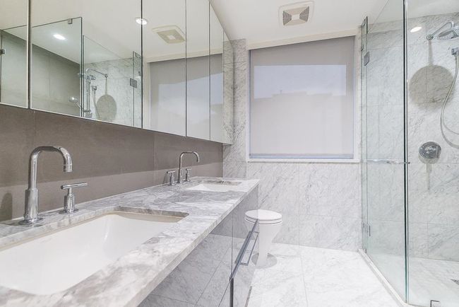 Full bathroom featuring tile walls, a sink, a shower stall, and toilet | Image 20