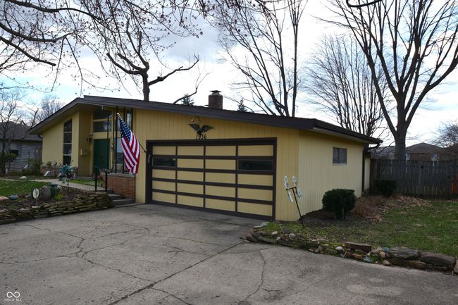 view of front of home with an attached garage, a chimney, fence, and concrete driveway | Image 4