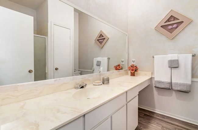 Full bathroom with vanity, wood finished floors, toilet, a stall shower, and baseboards | Image 10