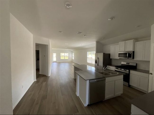 Kitchen featuring stainless steel appliances, open floor plan, a sink, dark wood finished floors, and recessed lighting | Image 4