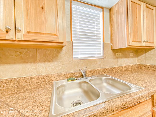 Kitchen view of light brown cabinetry, light countertops, and tasteful backsplash | Image 15