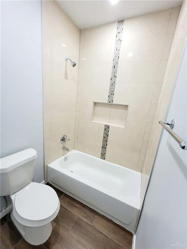 Full bathroom with shower / washtub combination, toilet, and wood finished floors | Image 8