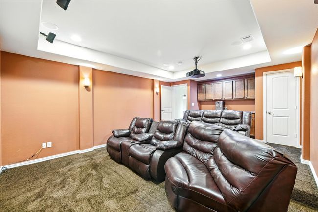 Home theater room featuring a raised ceiling, carpet flooring, and recessed lighting | Image 19