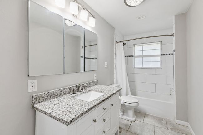 Bathroom featuring vanity, shower / tub combo with curtain, and tile patterned floors | Image 15