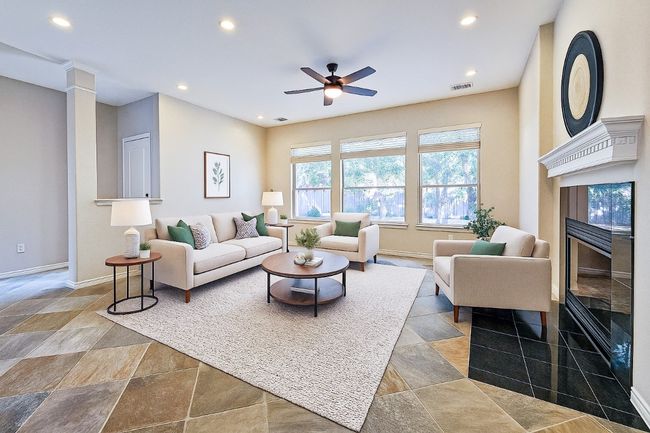 Living room with recessed lighting, a high end fireplace, a ceiling fan, stone finish flooring, and baseboards | Image 9