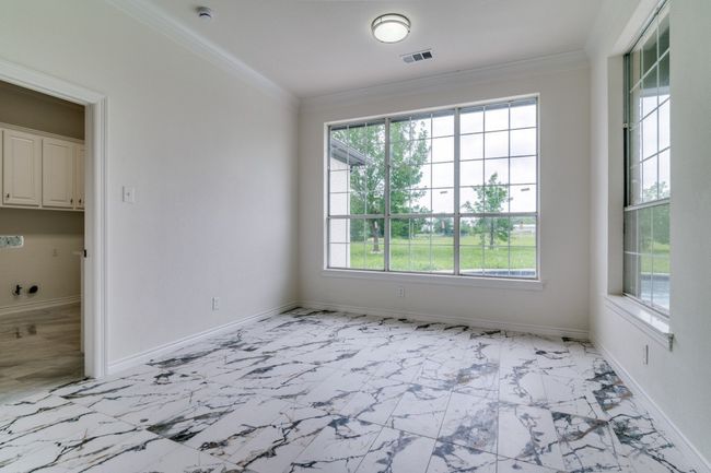 Spare room featuring light marble finish floors, crown molding, baseboards, and a smoke detector | Image 10