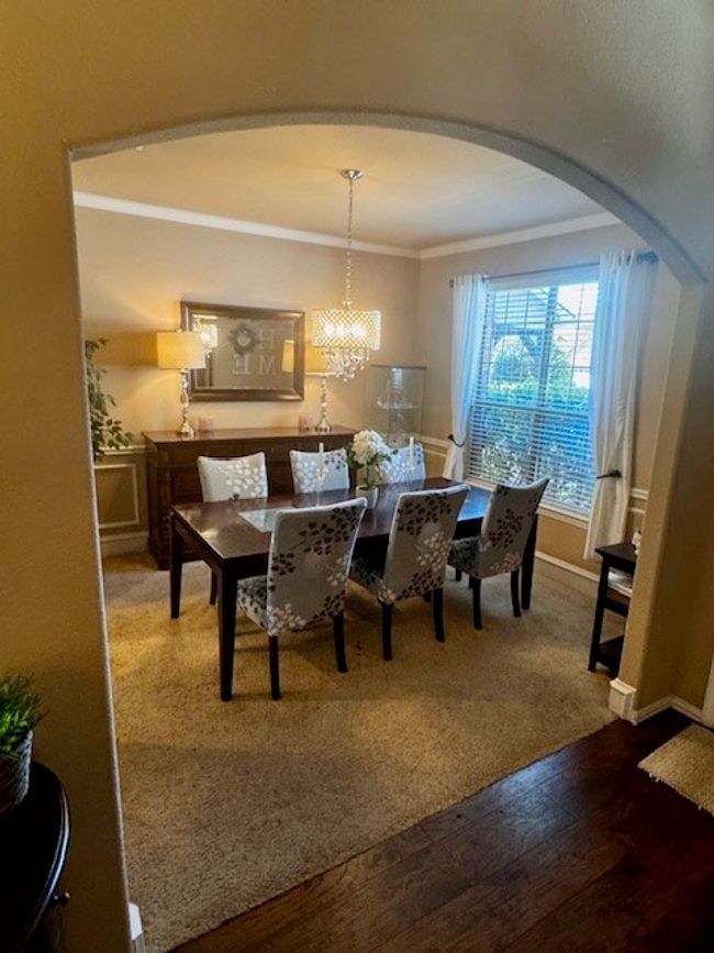 Dining space with a notable chandelier, baseboards, ornamental molding, arched walkways, and wood-type flooring | Image 7