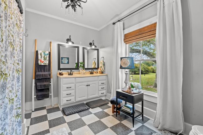 Bathroom with tile patterned floors, vanity, ornamental molding, and a chandelier | Image 18