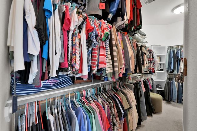 Large walk in primary closet with 2 entry doors & 3 rows of closet storage. | Image 20