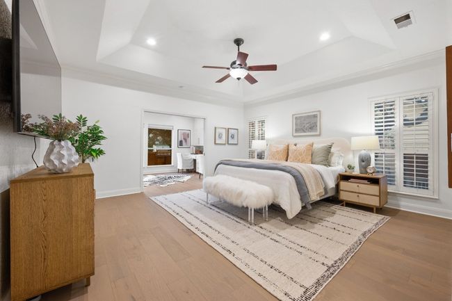 Bedroom featuring a tray ceiling, recessed lighting, wood finished floors, multiple windows, and a ceiling fan | Image 13