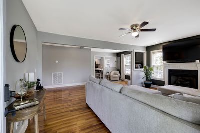 Entering in the front door to the cozy living room complete with fireplace and wood floors. | Image 3