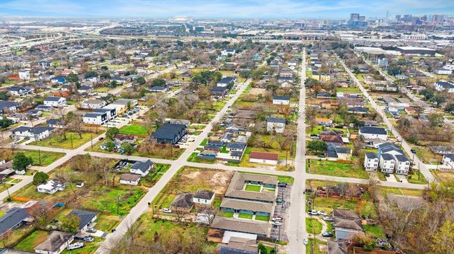 This aerial photo showcases an urban neighborhood with a mix of single-family homes, new construction and some modern buildings. The area features tree-lined streets and is situated near highway 610 & highway 288 , offering convenient access to the medical center and downtown areas. | Image 17
