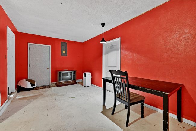 Unfurnished dining area featuring concrete flooring, a textured ceiling, and electric panel | Image 13