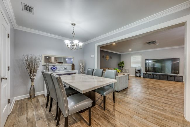 Dining space featuring a chandelier, light wood finished floors, and ornamental molding | Image 11