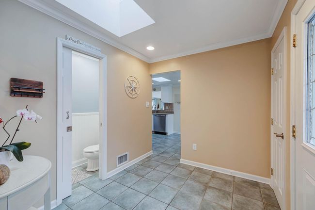 Entryway featuring visible vents, recessed lighting, a skylight, ornamental molding, and light tile patterned floors | Image 16