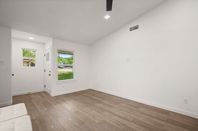 Unfurnished living room with wood finished floors, ceiling fan, and lofted ceiling | Image 9