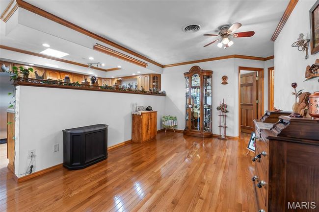 Living room with light wood-style floors, ceiling fan, ornamental molding, and recessed lighting | Image 62