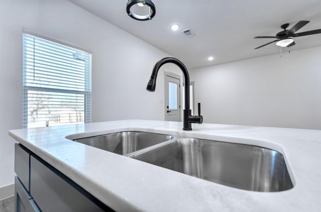 Room details featuring light countertops, a sink, visible vents, and recessed lighting | Image 7