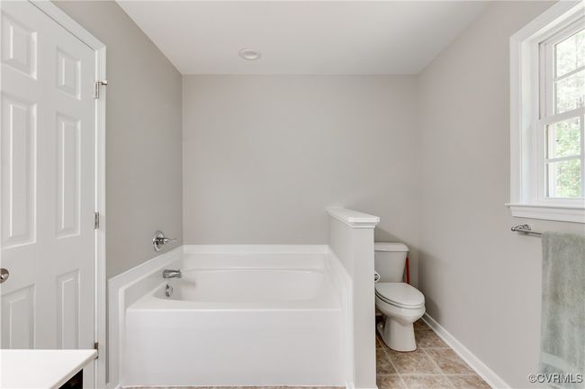 Full bathroom featuring a bath, toilet, tile patterned flooring, and baseboards | Image 19