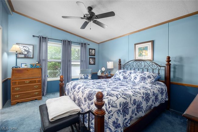 Bedroom featuring ornamental molding, lofted ceiling, carpet, and ceiling fan | Image 34