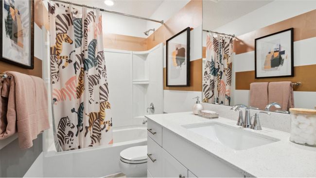 (Photo of decorated model, actual home's finishes will vary) This shared full bathroom showcases a full-width vanity mirror and a shower-tub combination. | Image 19