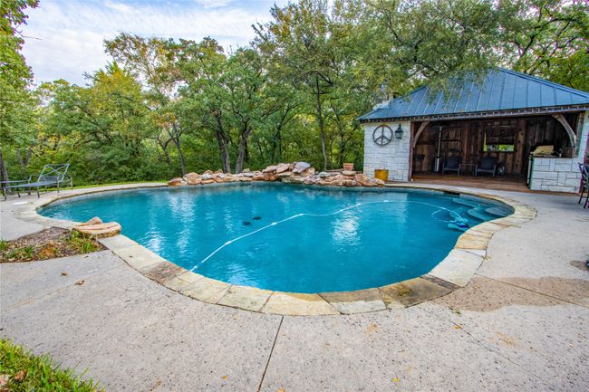 Pool with a storage structure, an outdoor structure, and a patio area | Image 25