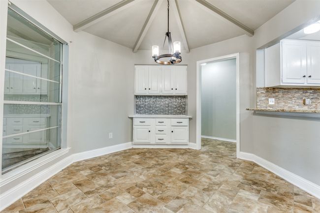 Unfurnished dining area featuring a chandelier and baseboards | Image 12