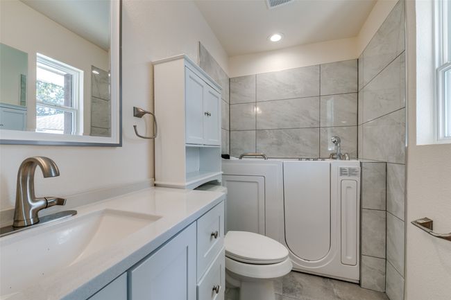 Third full bath added within this past year and is an ensuite with the third secondary bedroom. The owner is willing to change the current tub back to a standard bathtub with a reasonable offer. | Image 19