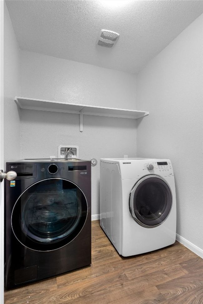 Laundry area featuring washer and clothes dryer, wood finished floors, and baseboards | Image 24