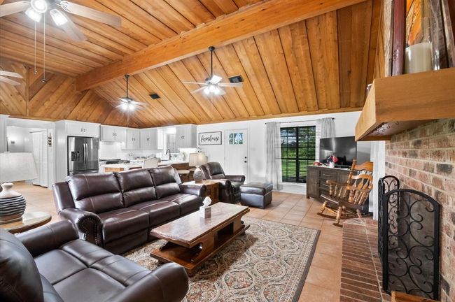 The living room offers a wood-burning fireplace with a surrounding hearth. The interesting thing here is what you can't see - the outside cleaning door for convenience without the mess in your home! | Image 13