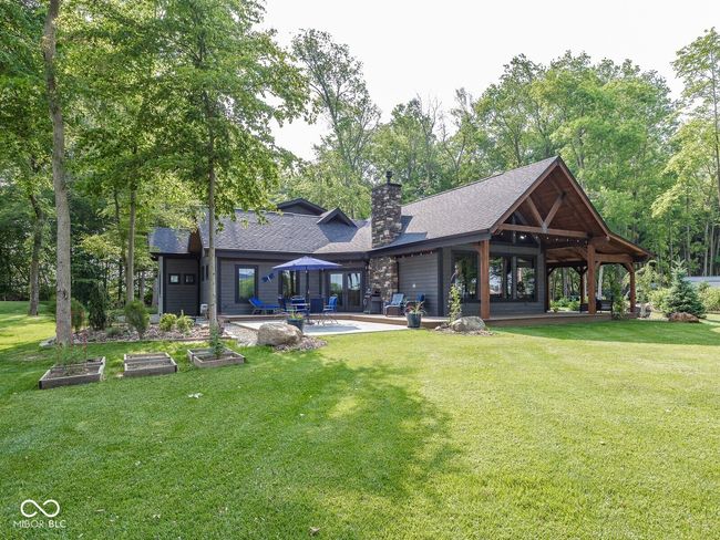 rear view of property featuring a patio area, a lawn, a shingled roof, a chimney, and a gazebo | Image 42