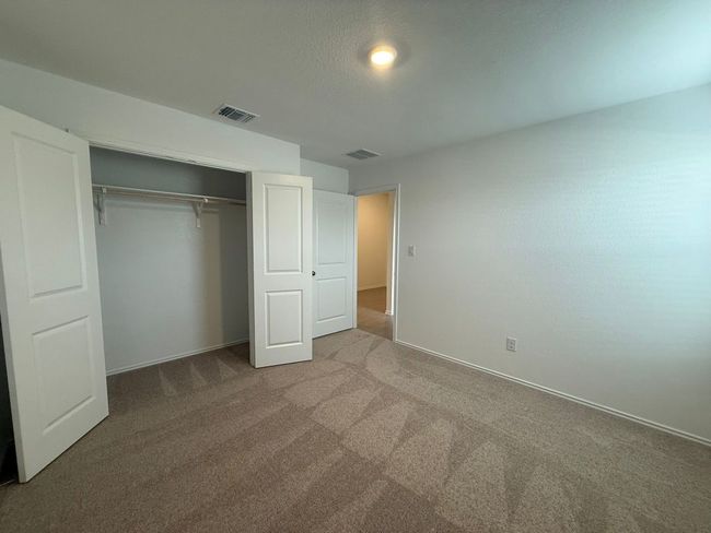 Unfurnished bedroom featuring carpet floors, a closet, and baseboards | Image 11