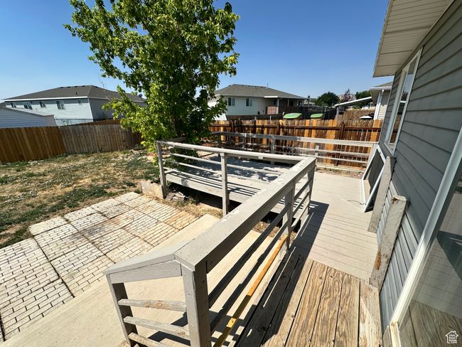 Wooden terrace featuring a fenced backyard, a patio area, and a residential view | Image 23